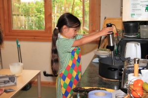 Wharfedale Montessori School - a young child uses a food mixer to make soup